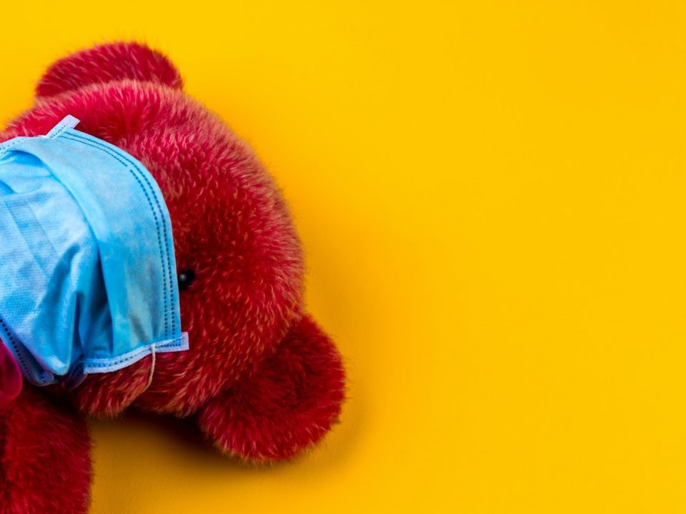 red bear plush toy on yellow surface